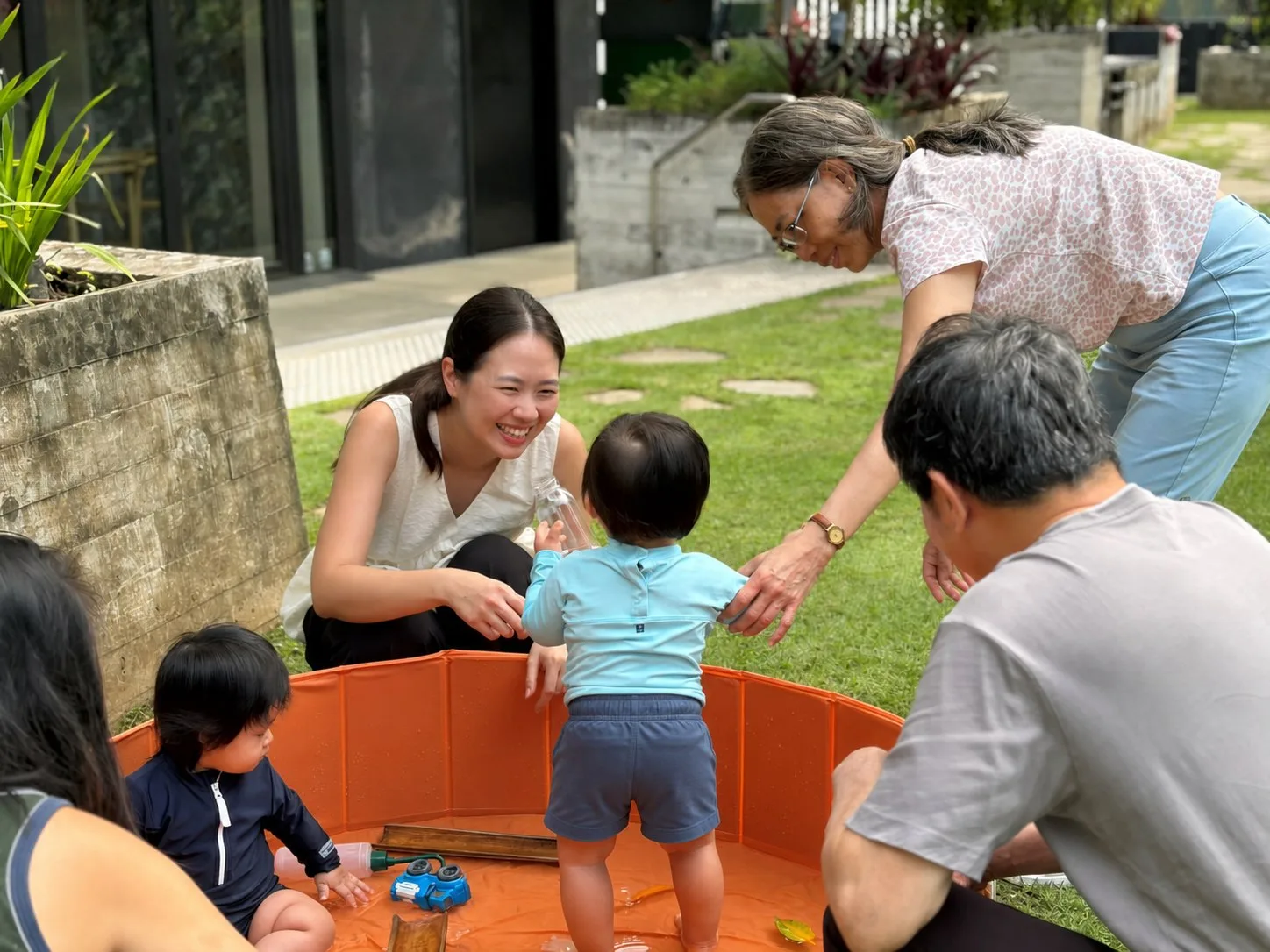 A family enjoying water play in our outdoor urban garden