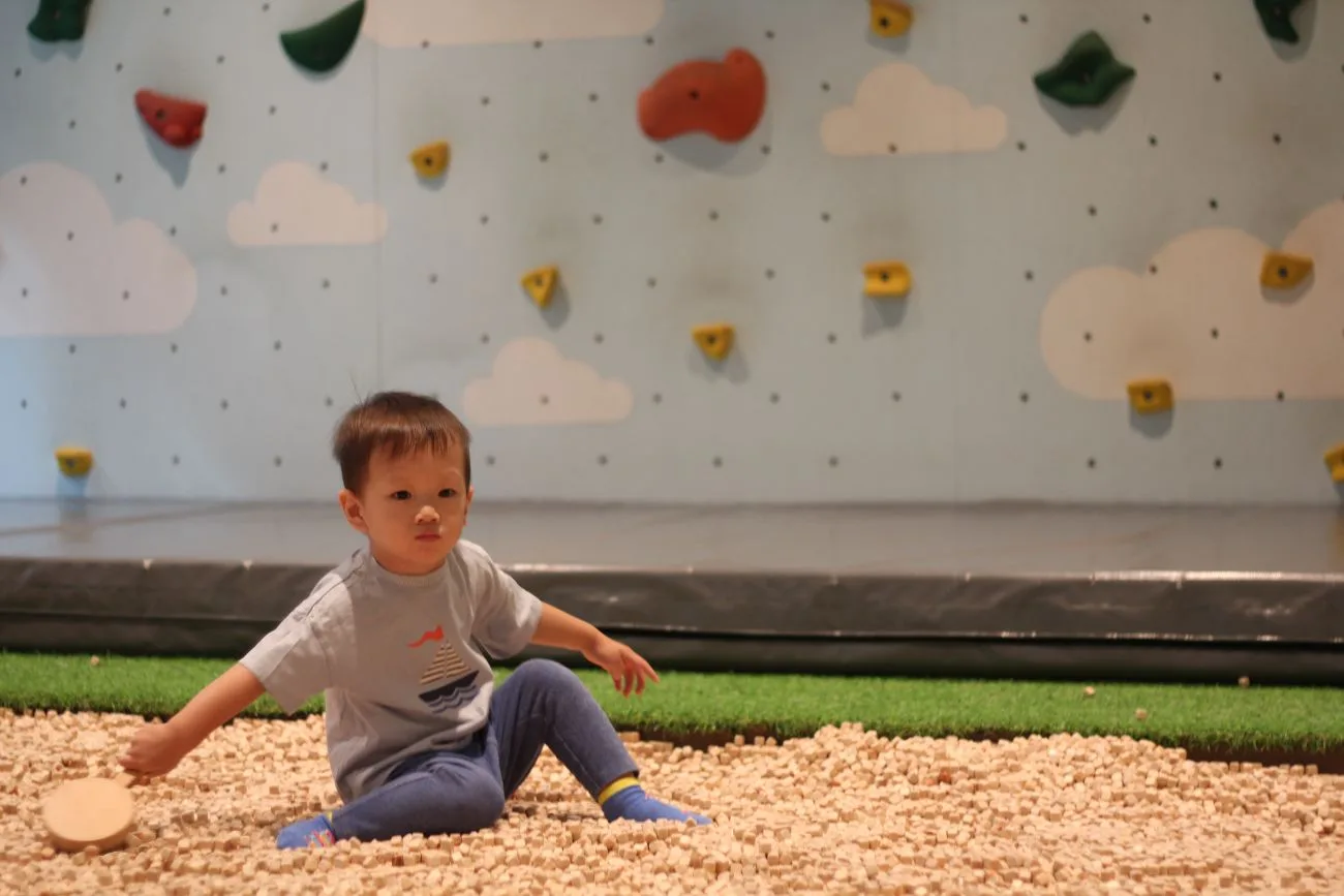The climbing wall and pebble pit at the preschool playground next door