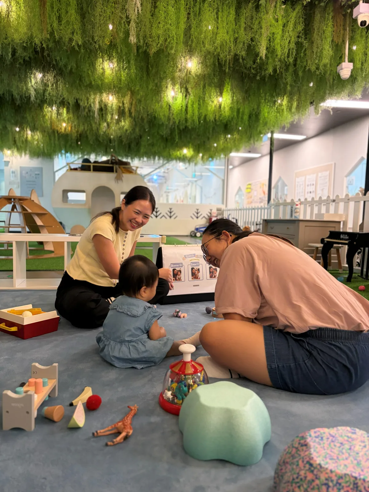 Therapist and parent playing with a toddler in the indoor playground